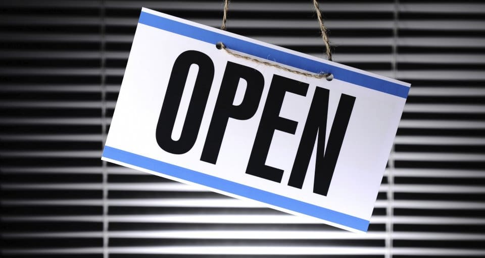 open for business sign hanging in window